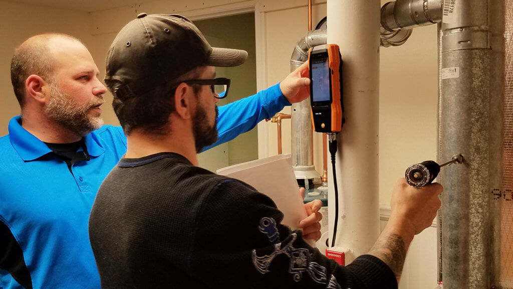 Supervisor training coworker about energy efficient technique with a device