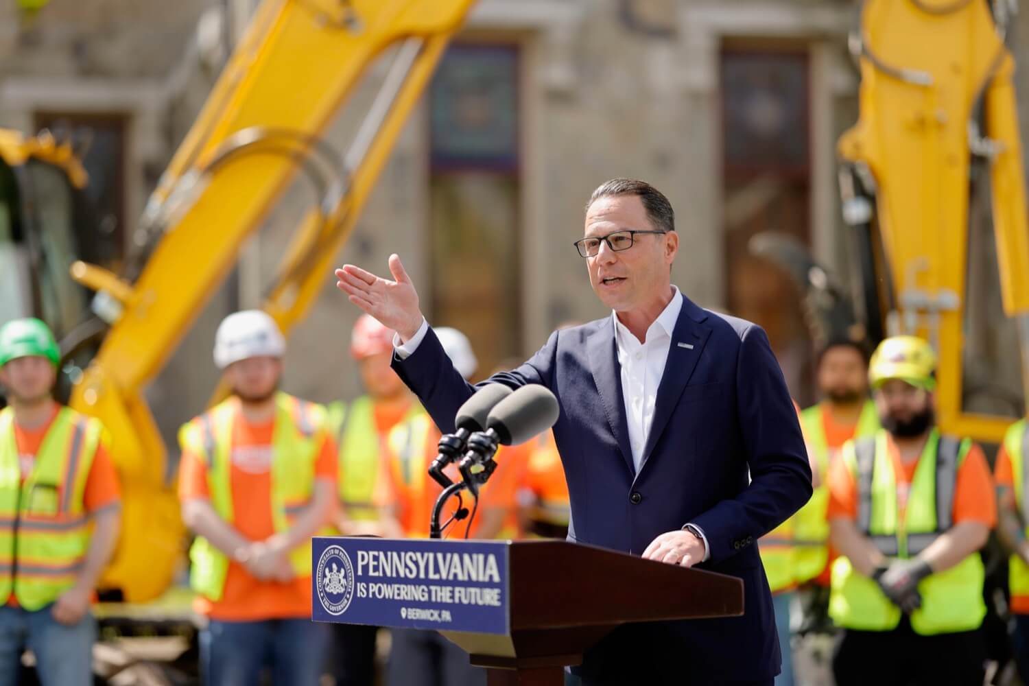 Pennsylvania Governor Josh Shapiro speaking from an outdoor podium at the Amazon AI Infrastructure Investment Plans