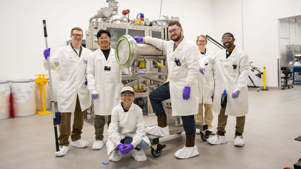 TerraPower Isotopes employees posing for a picture around radioisotope equipment