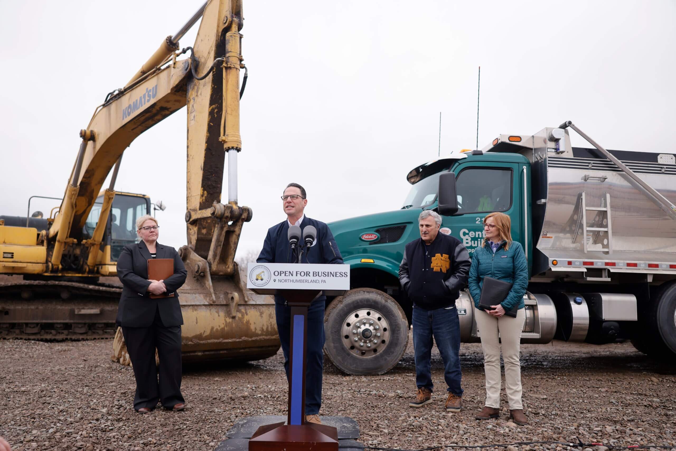 Pennsylvania Governor Josh Shapiro speaking from an outdoor podium in Northumberland County with local officials